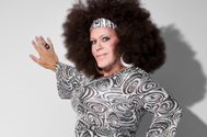 gay drag queen portrait against a white wall