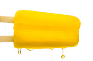 yellow popsicle with liquid dripping